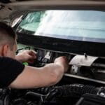 Mechanik diagnozuje instalację elektryczną w komorze silnika samochodu