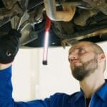 Mechanik diagnozuje podwozie samochodu na podnośniku w warsztacie