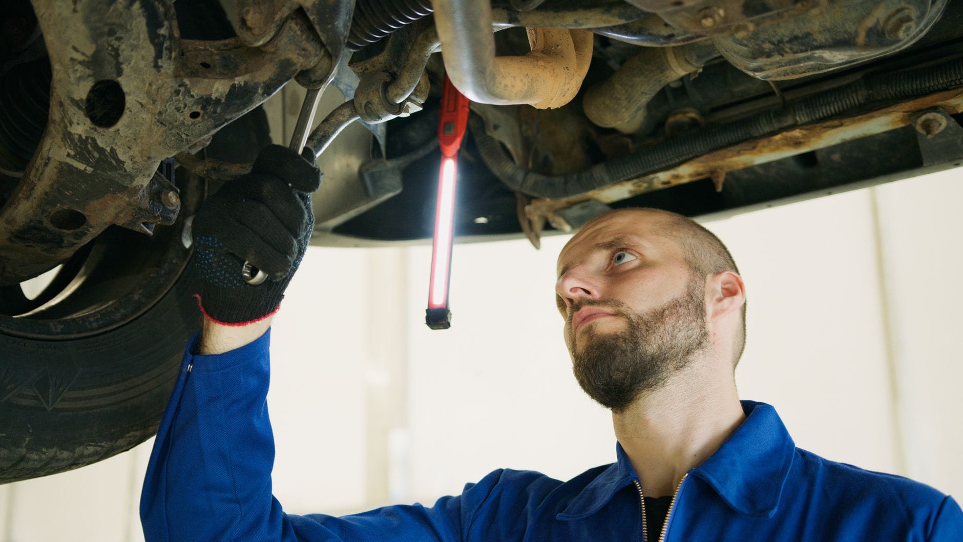 Mechanik diagnozuje podwozie samochodu na podnośniku w warsztacie