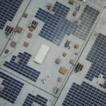 Panele fotowoltaiczne na dachu hali przemysłowej z lotu ptaka